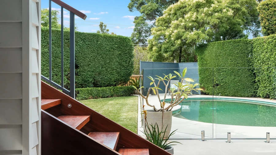 The Castlecrag home at dusk with the living areas opened to the deck