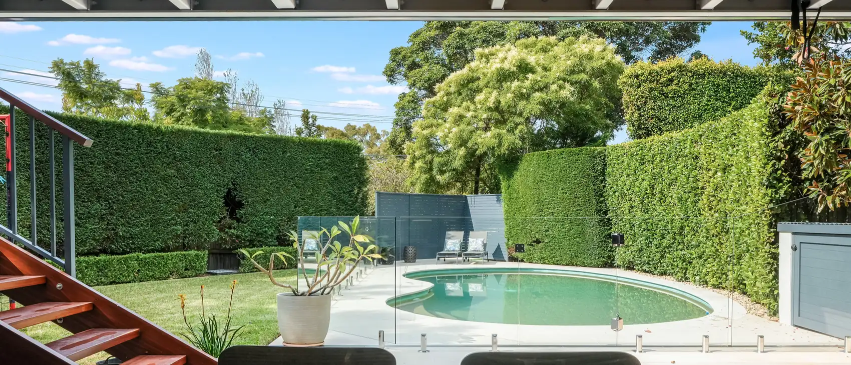 Looking out from the covered undercroft across the terrace to the pool, Castlecrag