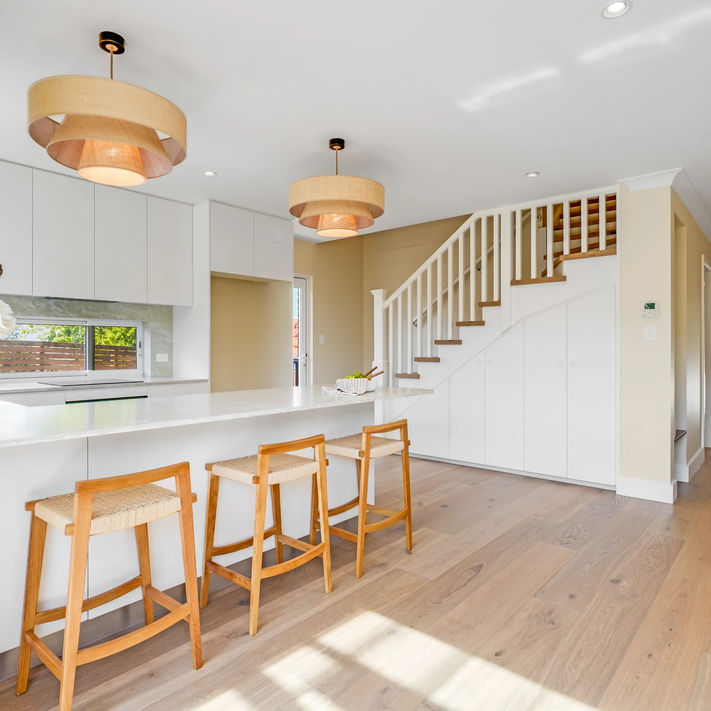 Kitchen island and pendant lighting, with the staircase to the upper level beyond, 27 Forsyth Street