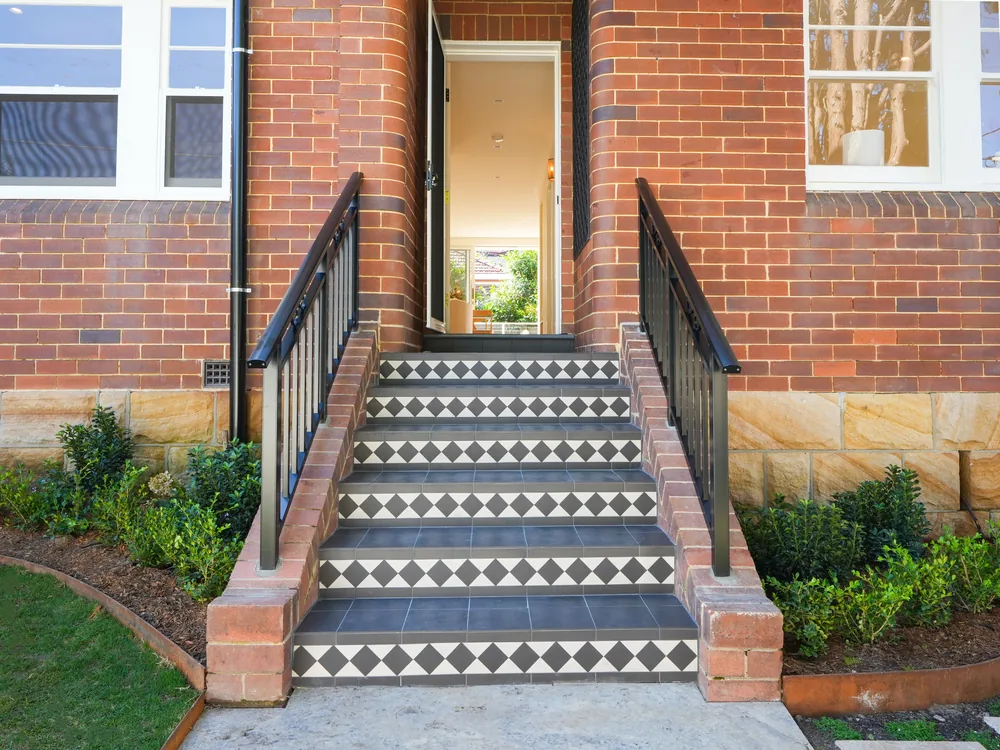 Tessellated tiled entry stair between the original brick piers