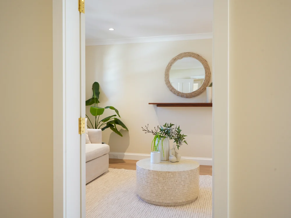 Looking through to the living room, round mirror above the console
