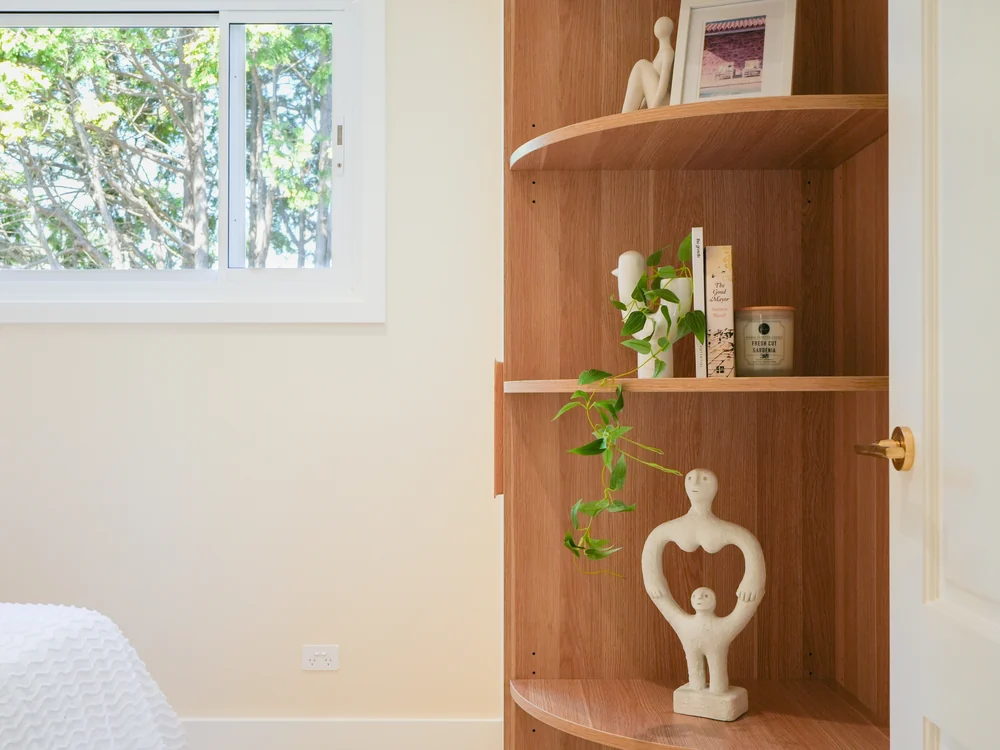 Bedroom with curved oak shelving beside the bed