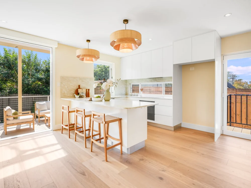 Kitchen with rattan pendants over the island bench, the deck through the sliding doors, 27 Forsyth Street