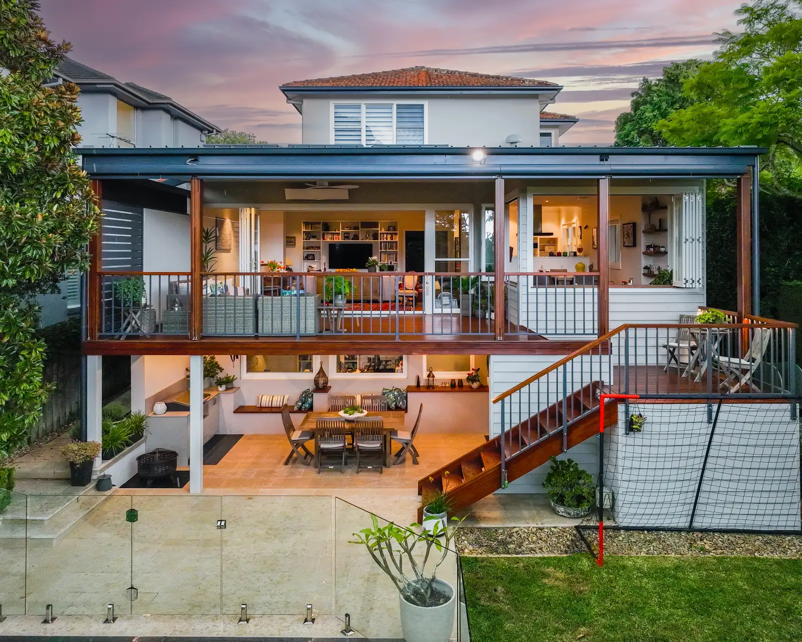 The rear of the Castlecrag house, the living level opened to a covered deck above a paved undercroft