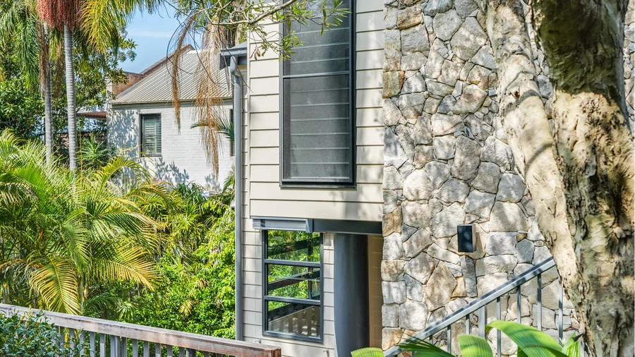 The three-level Mosman studio, weatherboard cladding meeting hand-placed stone
