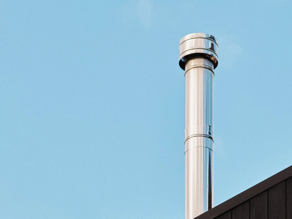 The flue against a clear sky above the gable