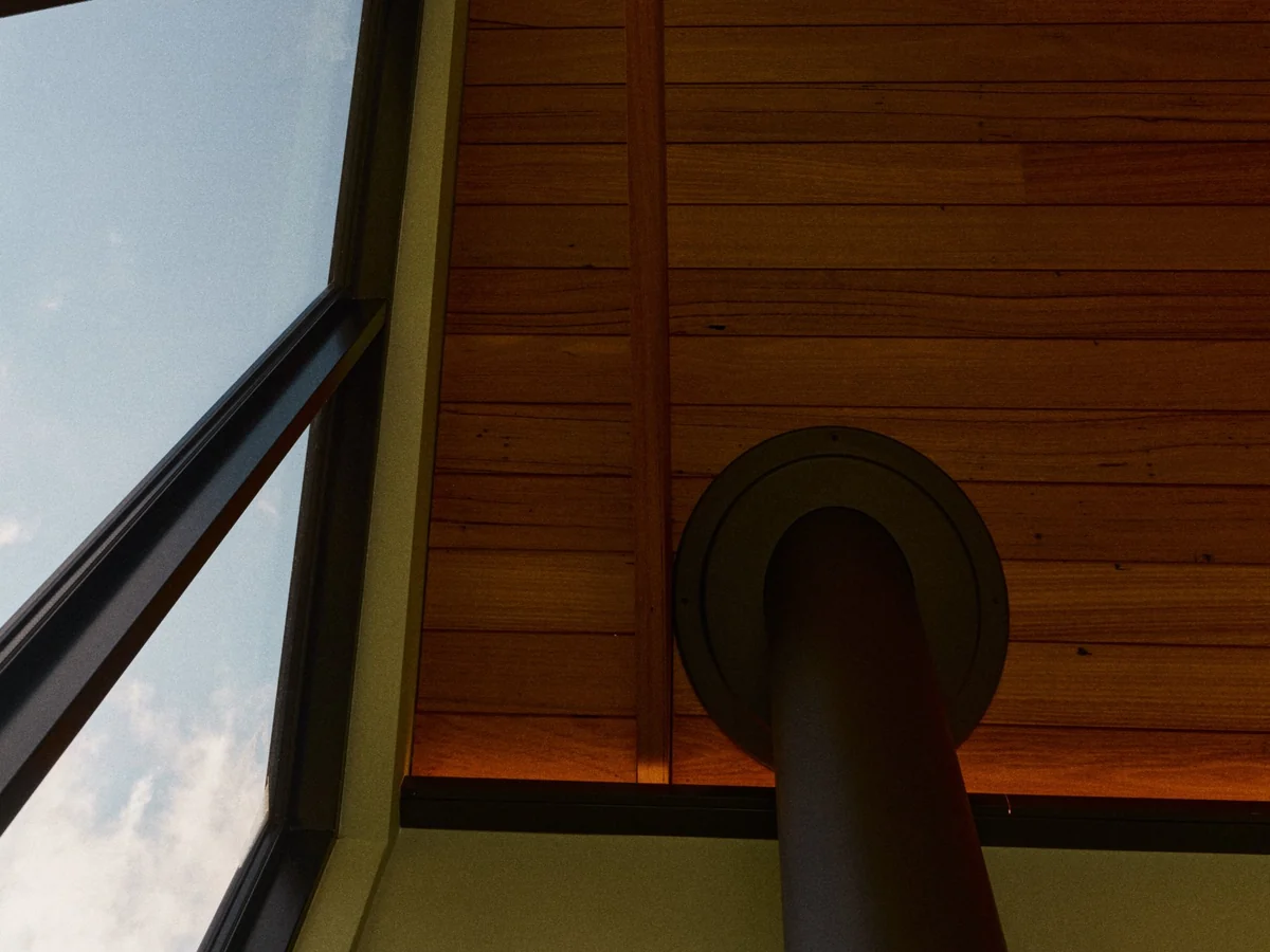 Timber ceiling, gable glazing and the wood heater flue
