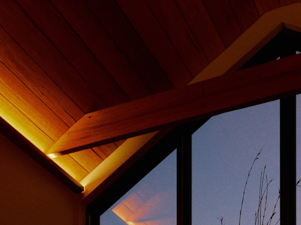 Concealed lighting along the timber ceiling at dusk