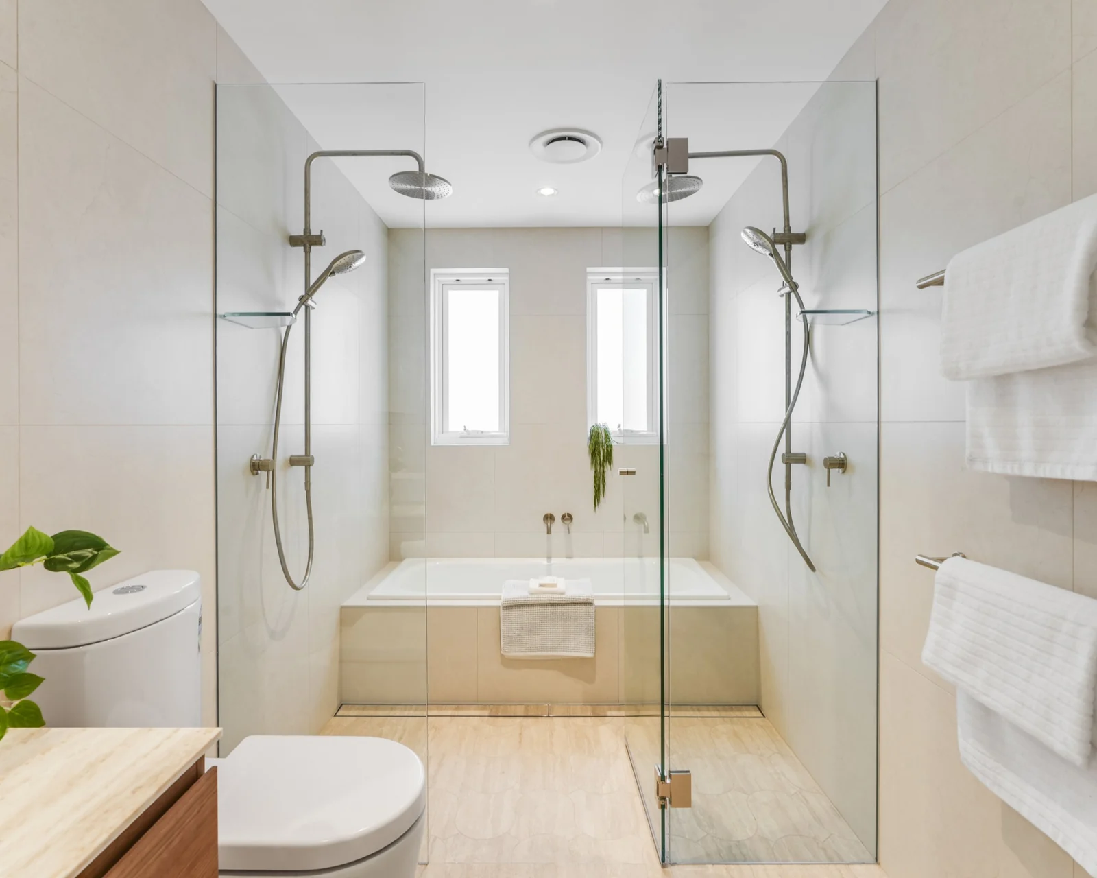 Bathroom renovation with twin rain showers either side of a tiled bath